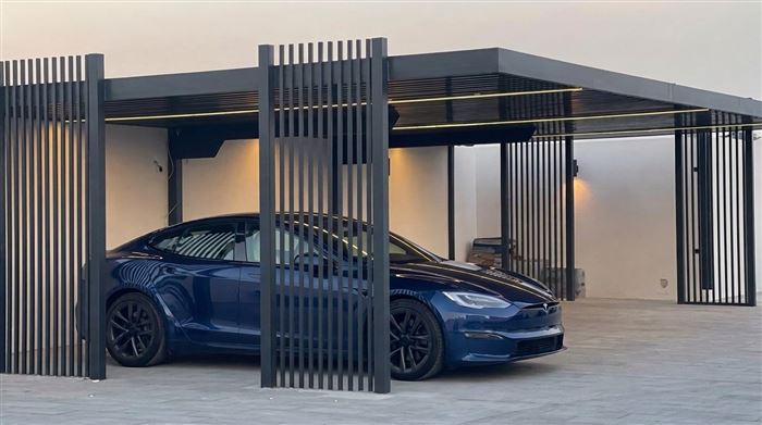 Steel slat carport with ambient lighting over a car