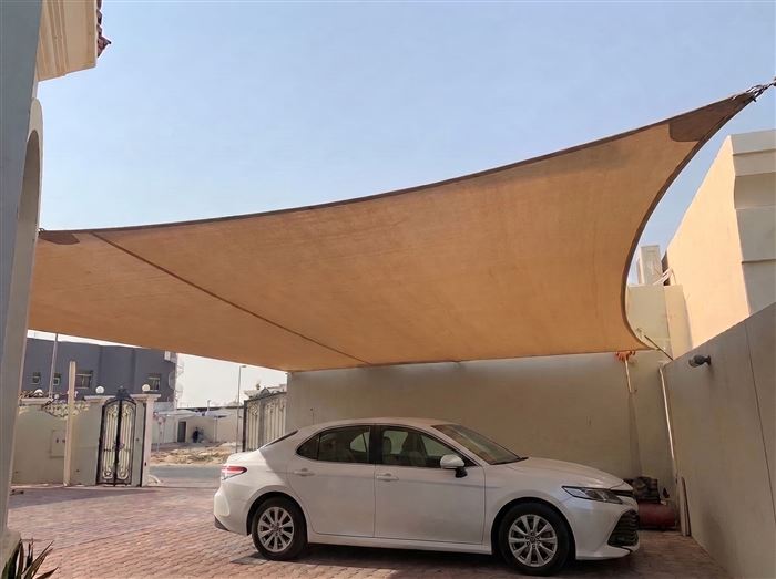 Tensioned fabric shade sail carport over a sedan