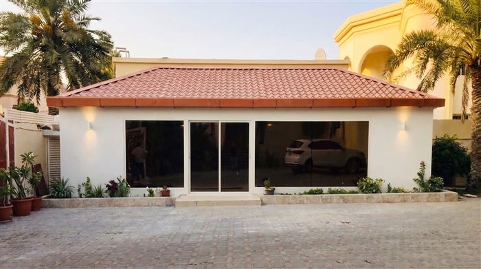 Traditional majlis annex with tiled roof and glass doors