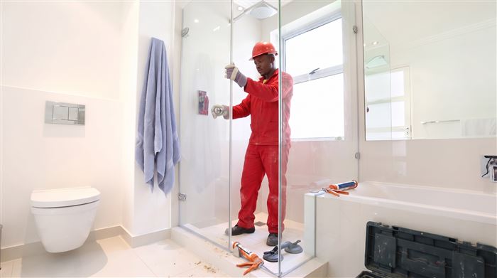 Technician installing a glass shower enclosure